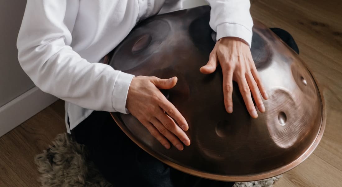 Close-up view of a brown handpan with hands