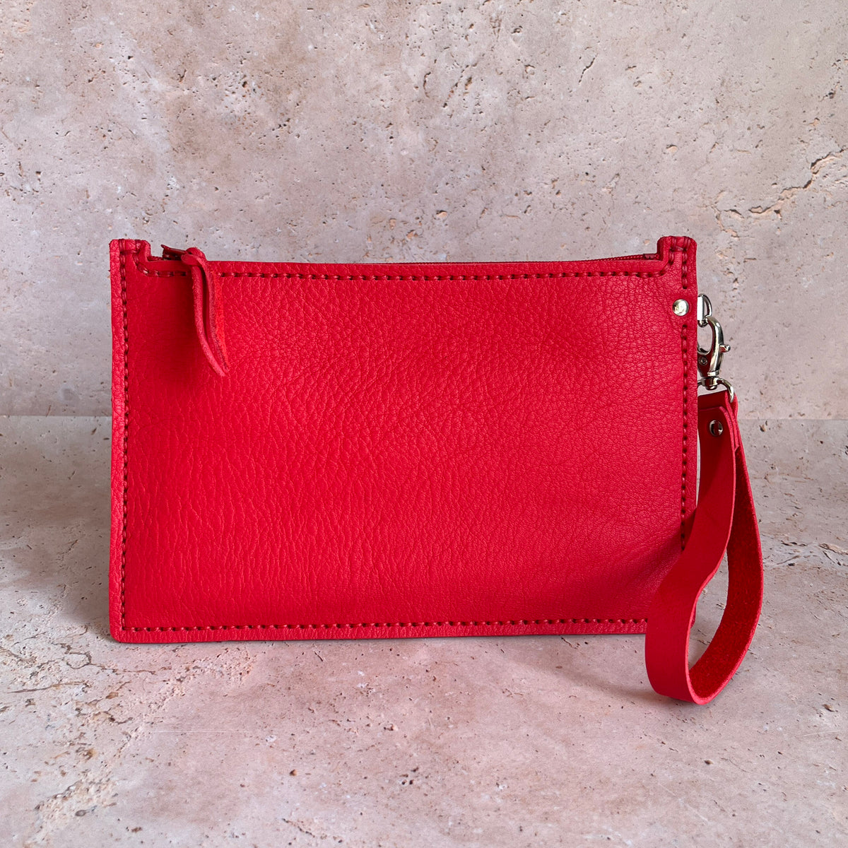 vue de dos grande pochette avec dragonne en cuir rouge maroquinerie faméthic